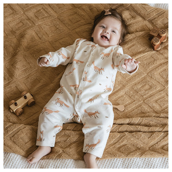 Adorable baby wearing a Gourbear vintage fox pattern baby romper, lying happily on a blanket comfortably 