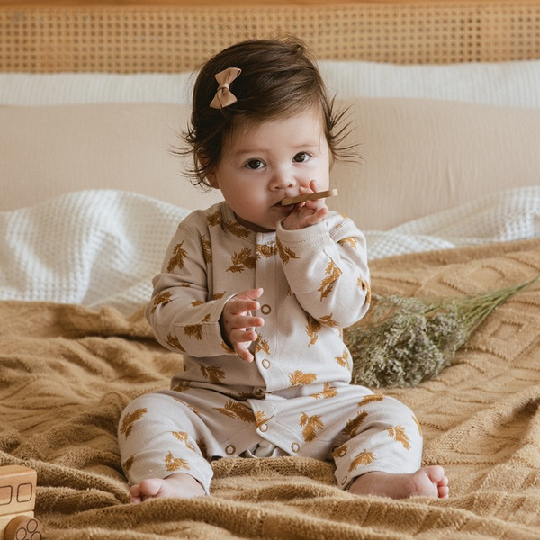 Adorable baby wearing a Gourbear vintage pattern Ear Of Wheatbaby romper, sitting happily on a blanket comfortably 